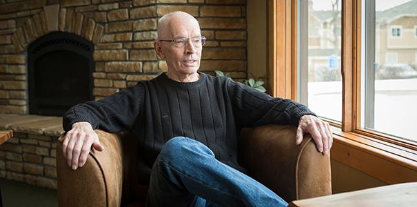 Jim Bowman sitting in leather chair in front of fireplace